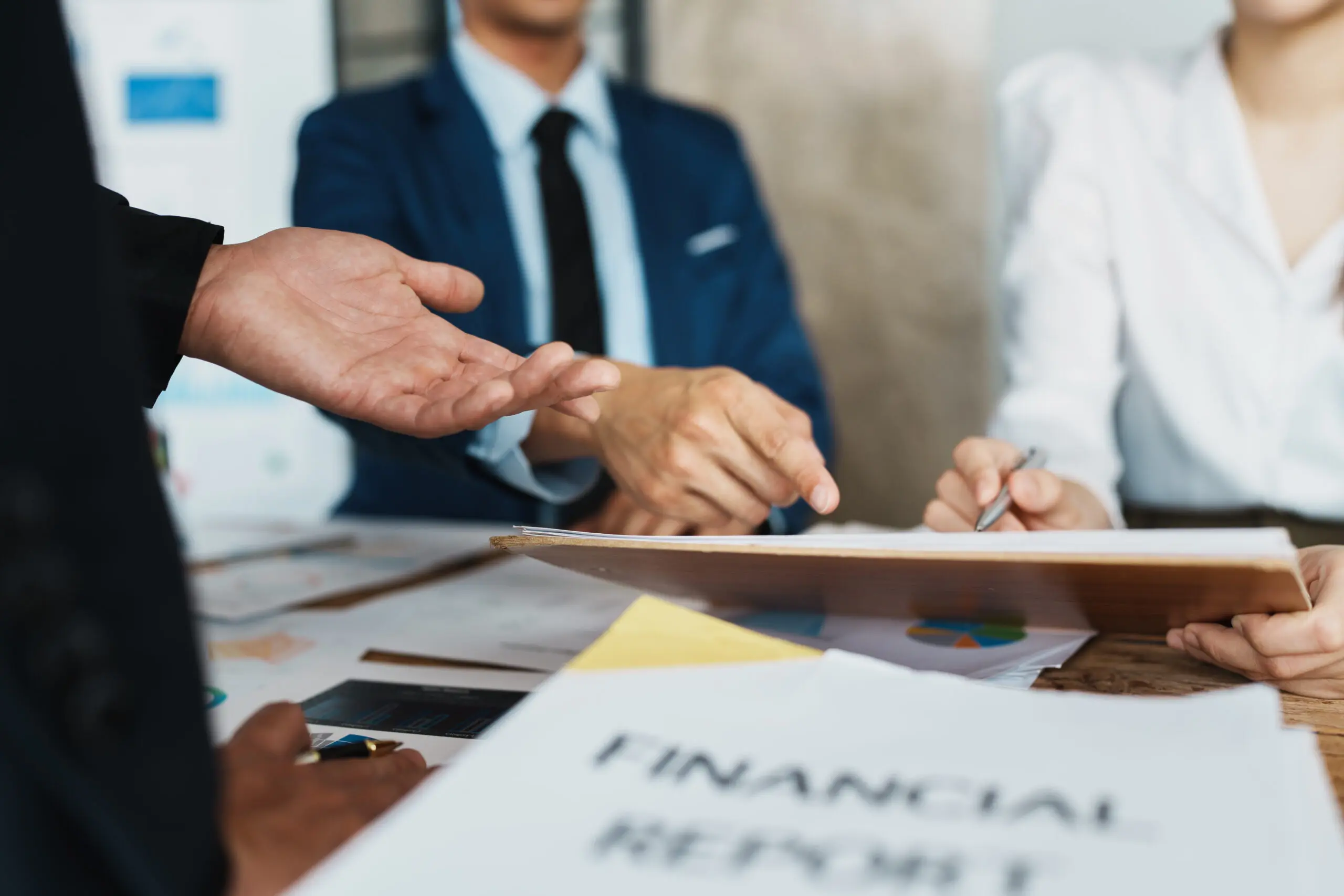 startup Asian business advisor meeting to analyze and discuss the situation on the financial report in the meeting room.Investment Consultant, Financial , teamwork ,brainstorming and accounting Professionals discussing over a document labeled "FINANCIAL REPORTS" at a business meeting.